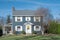 Blue Two Story House with White Trim and Side Porch