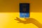 Blue Ukraine biometric passport on the energizing yellow background with silhouette of a woman hand. Immigration.