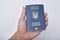 Blue Ukrainian passport in a man`s hand. White background