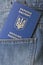 Blue ukrainian passport in pocket of jeans closeup