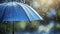Blue umbrella under rainfall. closeup real drops in natural conditions