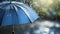 Blue umbrella under rainfall. closeup real drops in natural conditions