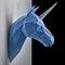 Blue unicorn`s head hanging on grey shadowed wall.