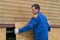 A blue-uniformed worker covers the lower part of the house with wooden boards