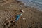 Blue used medical face mask thrown on beach by sea. Treatment of objects and waste of medical supplies. Stop water ocean
