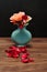 A blue vase with rose where one has lost its petals
