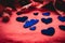 Blue velvet hearts on a red fabric background, with gift boxes for Valentine`s day. Valentine`s day in soft colors. A festive roma