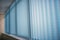 Blue vertical blinds on the long window on balcony. Modern interior design. Closed window from sunlight