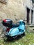 blue vespa in old italian street with old houses