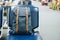 Blue vintage bag on seat at the interior of airport terminal. Travel and back to school concept