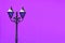 Blue vintage streetlamp against vivid purple concrete wall