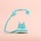 Blue vintage telephone on pink pastel color background.