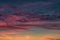 Blue violet red sunset sky background with evening fluffy curly rolling cirrostratus clouds. Good windy weather