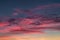 Blue violet red sunset sky background with evening fluffy curly rolling cirrostratus clouds. Good windy weather