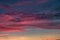 Blue violet red sunset sky background with evening fluffy curly rolling cirrostratus clouds. Good windy weather