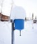 the blue washbasin on the street of a country house is covered with a thick layer of snow from above.