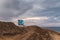 Blue watchtower on a hill near the beach under cloudy beautiful sky in Malibu, California