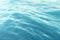 Blue water background with ripples, sea, ocean wave low angle view. Close-up Nature background. Hard focus with