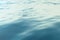 Blue water background with ripples, sea, ocean wave low angle view. Close-up Nature background. Hard focus with
