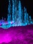 Blue water fountain and multi-colored lighted icicle walls in ice castle