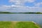 Blue water lake with green grass shore on a sunny landscape