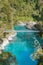Blue water lake with suspension bridge in tropical jungle