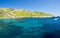 Blue water and sailing motor boat near town Mgarr, Gozo island