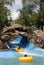 Blue water slide, stone grotto and swimming pool with children .