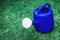 Blue watering plastic pot on a green grass field