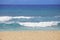 Blue waters and waves on a Hawaiian beach on sunny day