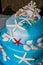 Blue Wedding Cake decorated with red starfish and shell, Marine Theme