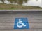 blue wheelchair logos on wood boardwalk near river