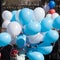 Blue and white balloons crowd round shiny