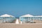 Blue and white beach cabanas lined up and ready for beachgoers in Viareggio, Italy