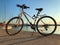 Blue and white bicycle of the HEAD company parked near the sea. Sarafovo fishing port near Burgas, Bulgaria at sunset.