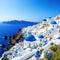 a blue and white church on a cliff overlooking the ocean and a blue dome with a cross on roof and a bell