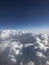 Blue and white clouds. Thousands of kilometers above the Earth. Airplane or aircraft cabin. Turn off the lights during the flight.