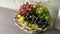 Blue and white grape clusters in the basket on the table