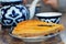 blue-white national pattern on a teapot and two bowls a piece of baklava