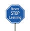 Blue and white Never Stop Learning stop sign