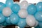 Blue and white party balloons inflated and tied together on festive outdoor background