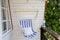 Blue and white striped pattern string and cotton hammock hanging chair, white painted wooden board background