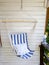 Blue and white striped pattern string and cotton hammock hanging chair, white painted wooden board background. .