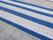 Blue and white striped pedestrial crossing and a gray sidewalk