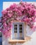 blue window of typical white house in greek island, pink bougainvillea in santorini