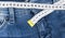 A blue woman jeans and ruler, concept of diet and weight loss. Jeans with measuring tape. Healthy lifestyle, dieting, fitness.