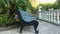 A blue wooden bench with black cast legs stands in the park