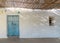 Blue wooden door and small window of abadoned church Ermita de Sant Antoni y Sant Jaume in Cap Blanche, Altea, Spain