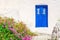 Blue wooden door, white wall and flowers, Greece