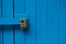 Blue wooden doors locked with modern yellow lock
